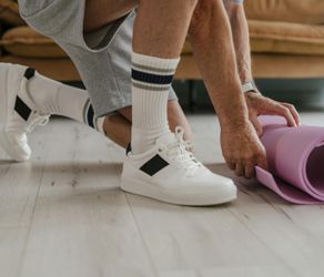 Close-up of a yoga mat and a water bottle on a wooden floor.